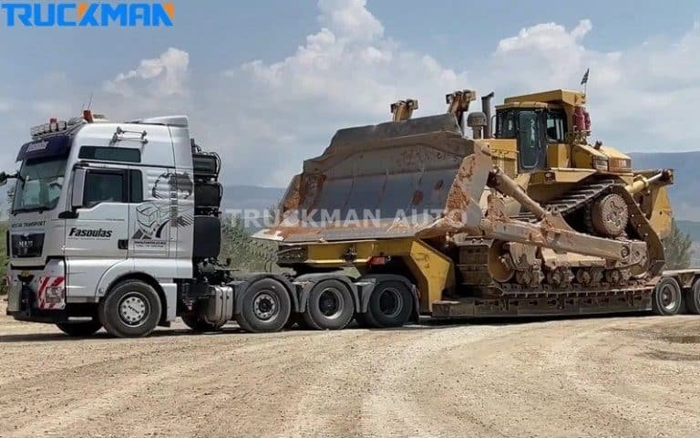Camião semirreboque de chassis baixo para serviço pesado transportando um grande bulldozer amarelo, demonstrando a elevada capacidade de carga e o design robusto do reboque
