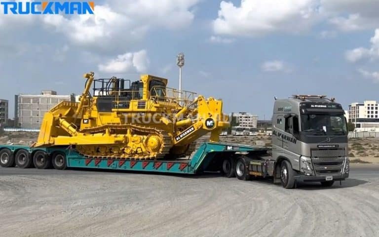 Camião semirreboque de plataforma baixa a carregar uma grande escavadora amarela - construção robusta e eficiência de transporte