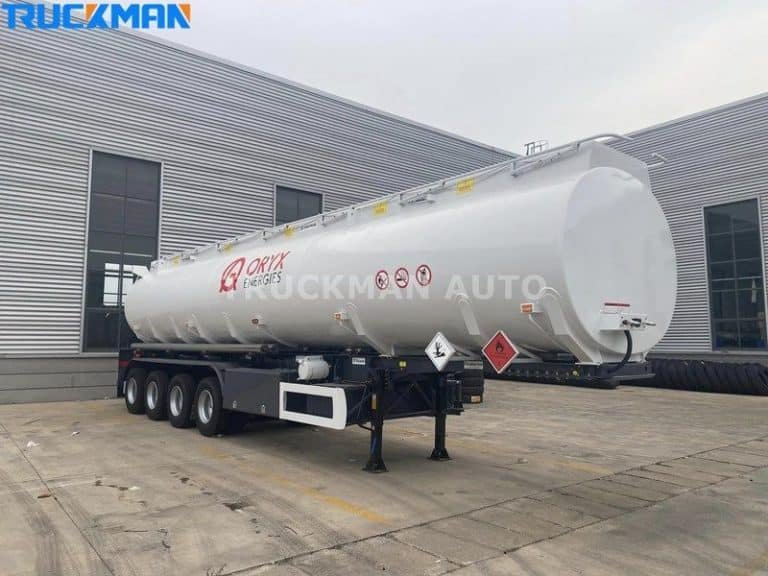 Reboque branco estacionário de um camião-cisterna para produtos químicos da Oryx Energies com placas de perigo no depósito da Truckman Auto