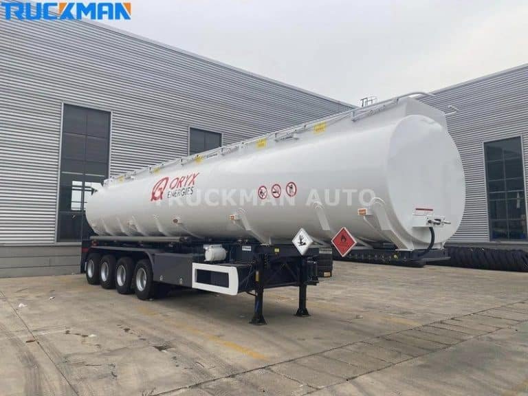 Camião-cisterna branco pronto para o transporte de mercadorias perigosas com sinais de aviso de segurança
