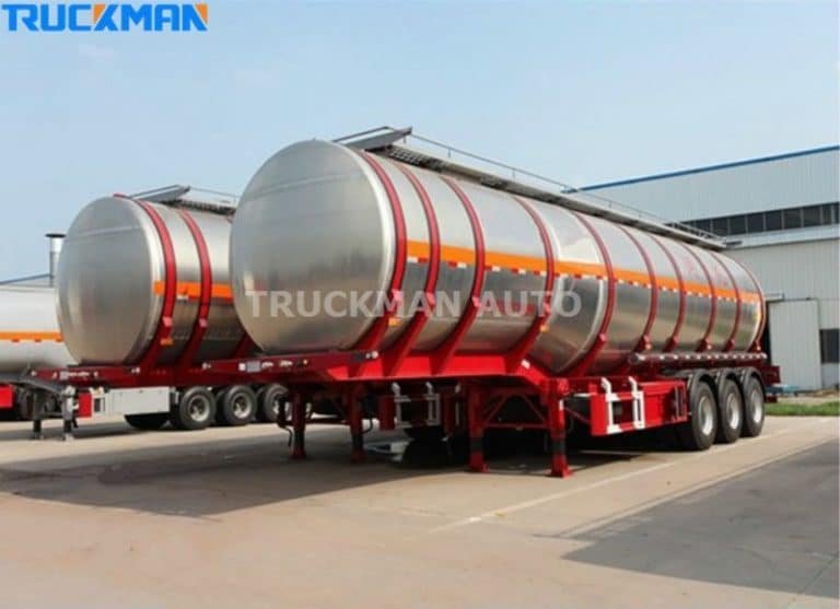 Fila de reboques-cisterna de aço inoxidável com riscas vermelhas na Truckman Auto, concebidos para o transporte seguro de materiais.