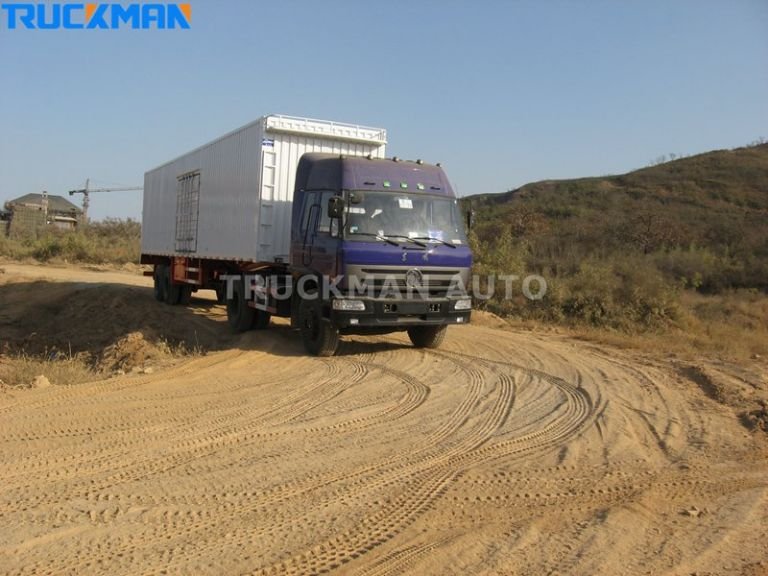 Camião com um reboque de carrinha a circular numa estrada de terra, transportando electrodomésticos e materiais de construção - Camionista Automóvel
